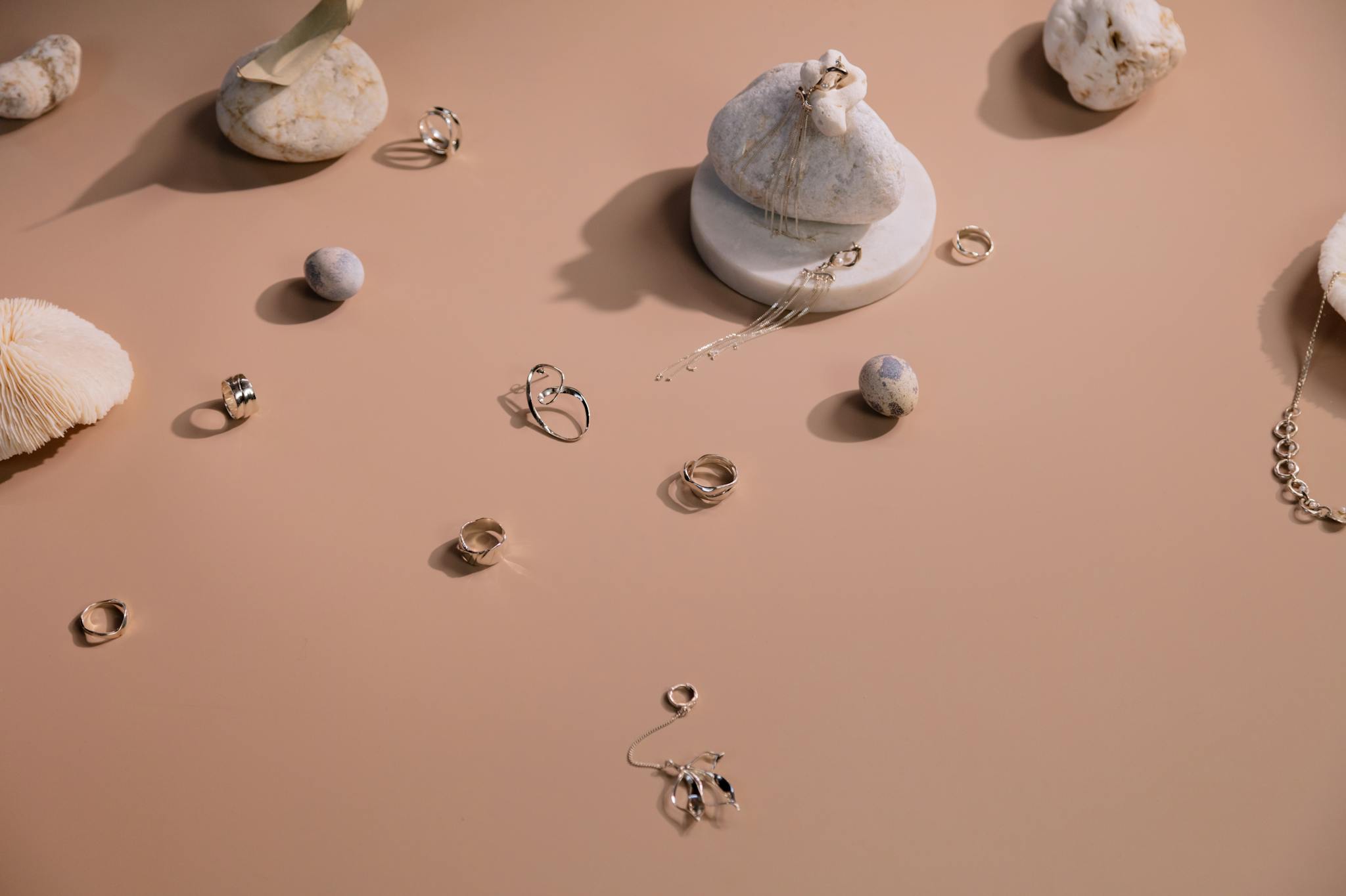 Stylish display of rings and earrings on a minimalist backdrop.